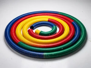 Kleurrijke luchtverdeelslangen in spiraalpatroon op witte industriële ondergrond, blauw rood geel en groen flexibele buizen